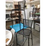 A metal Folding table and a pair of metal mesh bar stools.