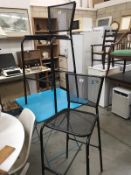 A metal Folding table and a pair of metal mesh bar stools.