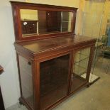 A mahogany glazed cabinet with mirror back.