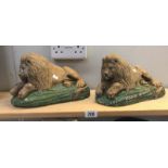 A pair of painted stone lion garden ornaments.