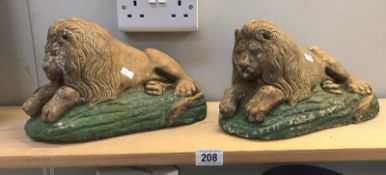 A pair of painted stone lion garden ornaments.