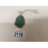 A large green agate pendant set in silver with attached silver chain.