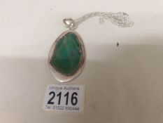 A large green agate pendant set in silver with attached silver chain.