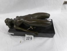 A bronze figure of a nude lady.