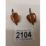 A pair of amber ear pendant set in silver, unusual design.