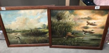 A pair of oil on canvas mallards in flight.