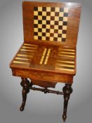 A Victorian sewing table with fold over games table top.