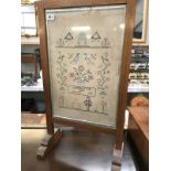 A fire screen depicting embroidery for Coronation day,