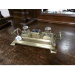 A brass inkstand with glass inkwells.