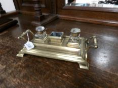 A brass inkstand with glass inkwells.