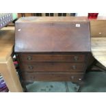 A 1930's mahogany bureau with string inlay on Queen Anne legs