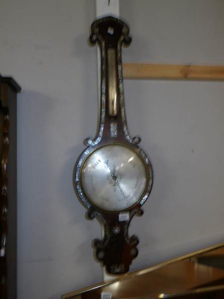 A 19th century wheel barometer inlaid with mother of pearl.