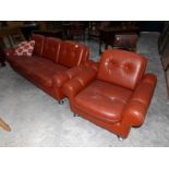 A tan leather 3 seat sofa with matching arm chair.