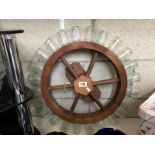 A spice rack in the shape of a ships wheel.