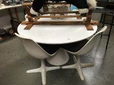 A white circular table and 4 chairs.