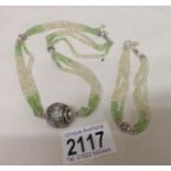 A peridot and crystal necklace with matching bracelet in silver.