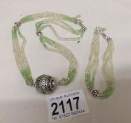 A peridot and crystal necklace with matching bracelet in silver.