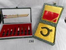A jade 'The Dragon Jade' amulet and a Chinese calligraphy set.