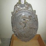 An oval lead wall plaque depicting cherubs.