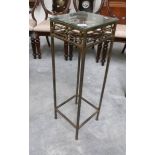 A metal plant stand with glass top.
