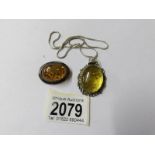 A silver amber pendant on chain and a silver amber brooch,