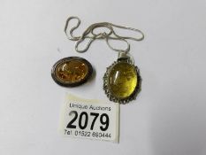 A silver amber pendant on chain and a silver amber brooch,