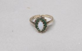 A 9ct gold ring set opal and emeralds, size M. Gross weight 2 grams.
