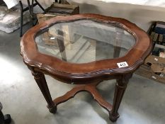 A glass and wooden topped coffee table