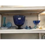 A shelf of glass items including a large Bristol blue vase/glass