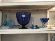 A shelf of glass items including a large Bristol blue vase/glass