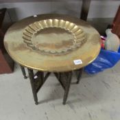 A brass topped table with folding base.