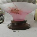 A large pink German glass bowl on wooden stand.