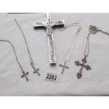 4 sparkly cross pendants on chains and a mother of pearl crucifix.