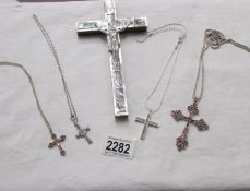 4 sparkly cross pendants on chains and a mother of pearl crucifix.