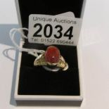 An unusual orange stone ring in a yellow gold wide shank, approximate totla weight 7.