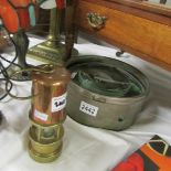 A world war 2 map magnifying glass and a small brass & copper miner's lamp.