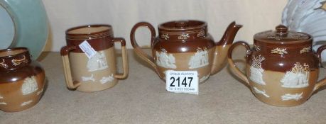 A miniature Doulton Lambeth 'Harvest' teapot, sugar bowl, milk jug and loving cup.