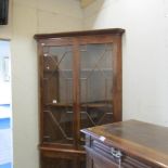 A glazed top corner display cabinet.