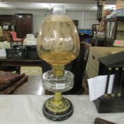 A Victorian oil lamp with glass font and acid etched amber glass shade.