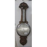 A carved oak barometer (glass cracked)