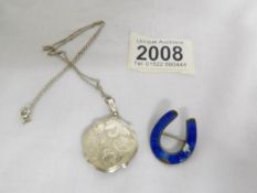 A silver locket on chain and a silver brooch.