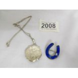 A silver locket on chain and a silver brooch.