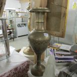 A tall Asian brass vase.