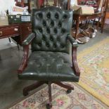 A green leather revolving desk chair.