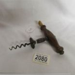 A 19th century walnut handled corkscrew with wine brush, circa 1840.