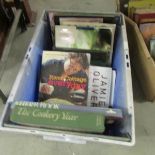 A box of assorted cookery books.