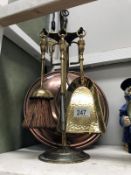 A copper warming pan and a brass companion set.