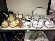 A shelf of crockery including tea sets etc.