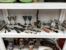 A shelf of silver plate, cutlery, letter openers etc.