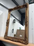 An ornate gilt framed mirror.